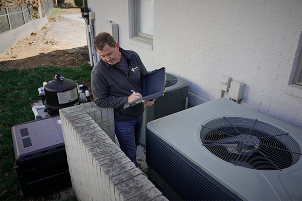 Trane Tech with checklist in front of HVAC units